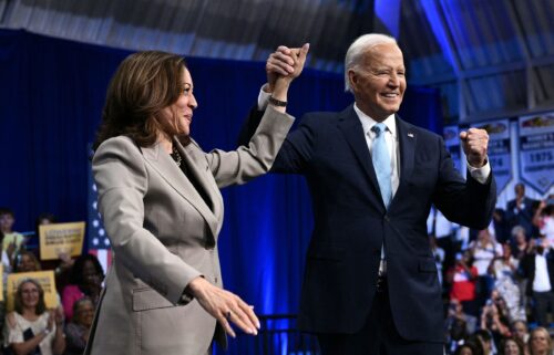 President Joe Biden and Vice President Kamala Harris clasp and raise their hands after speaking at Prince George's Community College in Largo