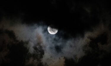 The moon is seen through the clouds during a partial lunar eclipse over Caracas