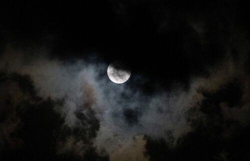 The moon is seen through the clouds during a partial lunar eclipse over Caracas