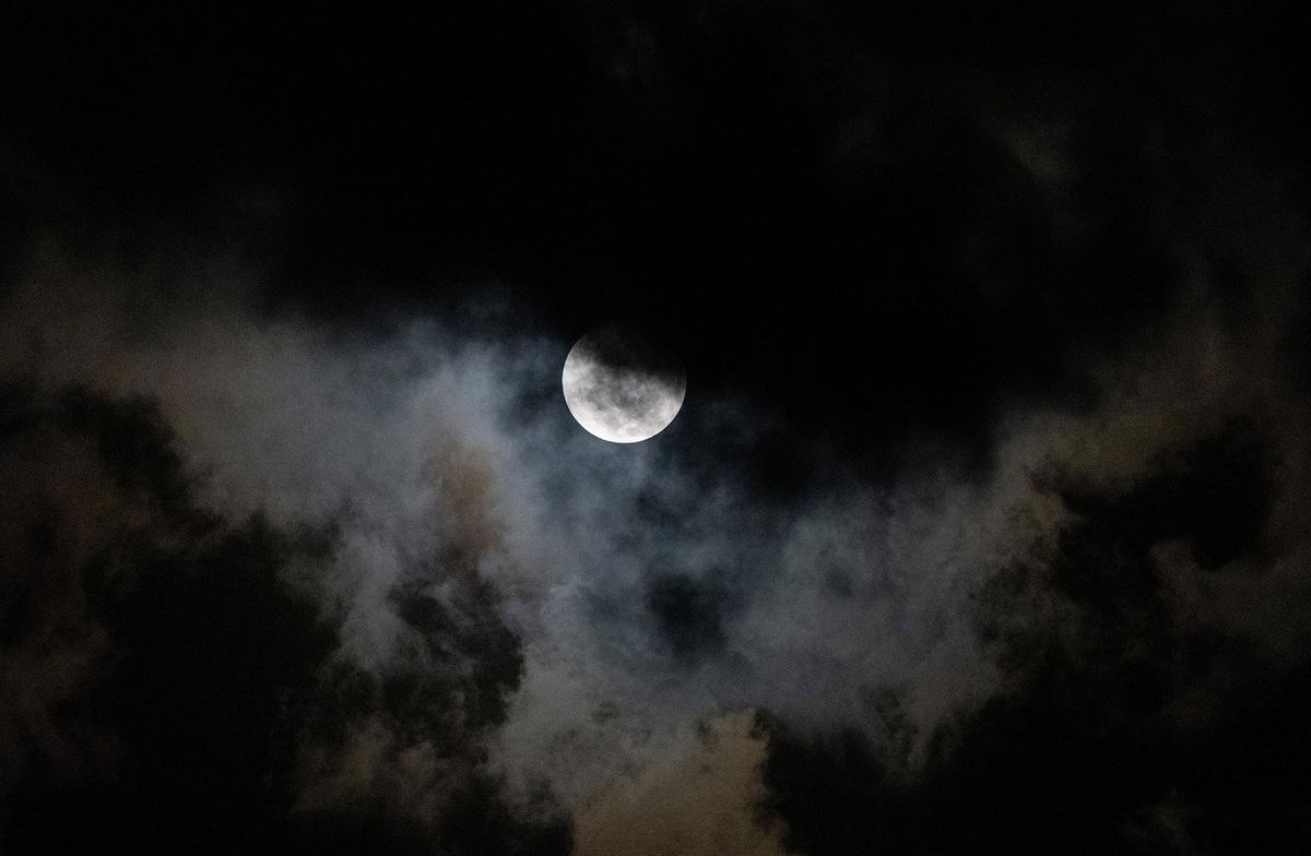 <i>Federico Parra/AFP/Getty Images via CNN Newsource</i><br/>The moon is seen through the clouds during a partial lunar eclipse over Caracas