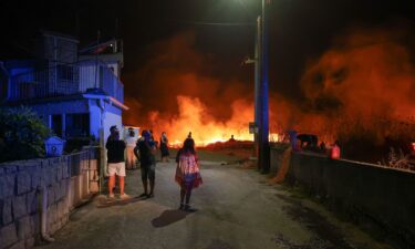 People watch a wildfire in Canas de Senhorim