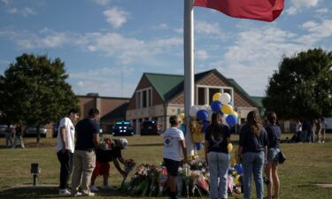 A man lays flowers at a makeshift memorial at Apalachee High School in Winder