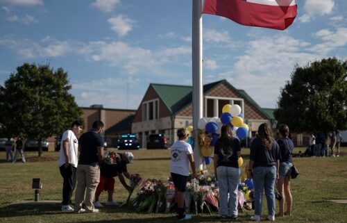 A man lays flowers at a makeshift memorial at Apalachee High School in Winder