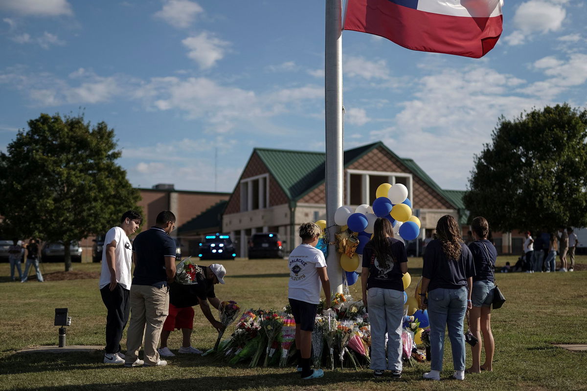 <i>Elijah Nouvelage/Reuters via CNN Newsource</i><br/>A man lays flowers at a makeshift memorial at Apalachee High School in Winder