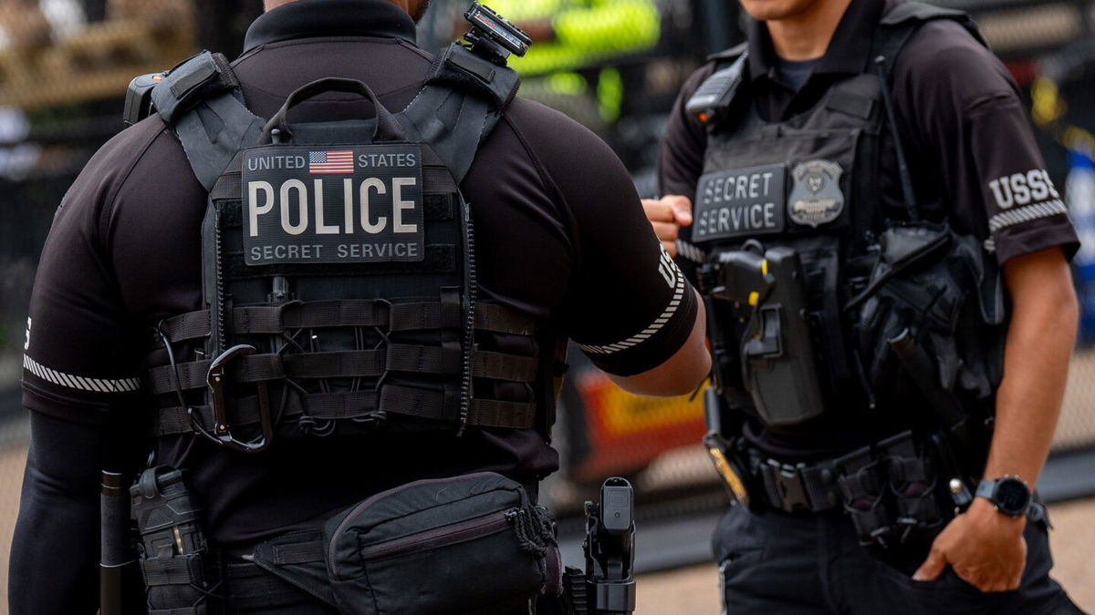 <i>Andrew Harnik/Getty Images via CNN Newsource</i><br/>Members of the Secret Service stand guard as workers put up additional security fencing around the White House on July 24 in Washington