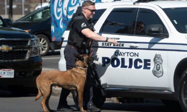 A police officer and his dog return to their vehicle after sweeping the Springfield City Hall grounds for explosives after bomb threats on September 12.