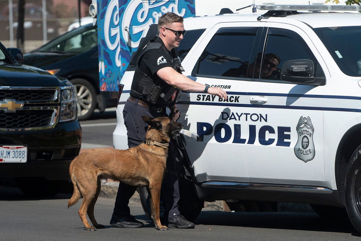 <i>Roberto Schmidt/AFP/Getty Images/File via CNN Newsource</i><br/>A police officer and his dog return to their vehicle after sweeping the Springfield City Hall grounds for explosives after bomb threats on September 12.