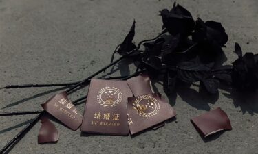 This picture shows a torn marriage certificate alongside some roses.