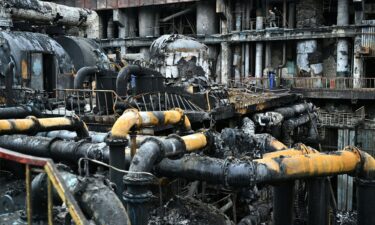 Workers remove debris in a turbine hall full of scorched equipment at a power plant in Ukraine in April 2024.