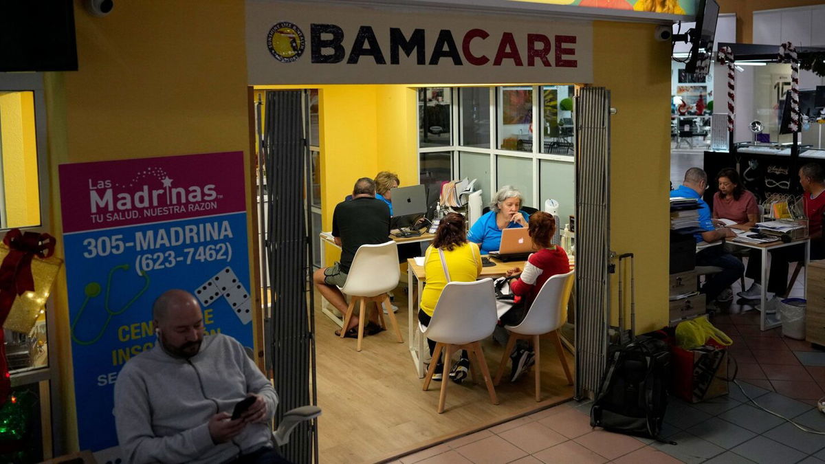 <i>Rebecca Blackwell/AP via CNN Newsource</i><br/>Insurance agents with clients at a shopping mall kiosk run by Las Madrinas de los Seguros