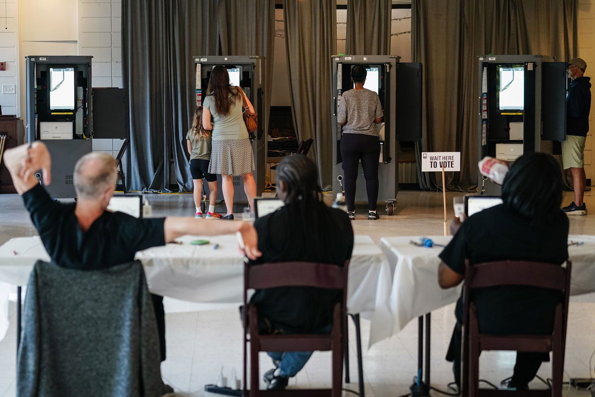 <i>Elijah Nouvelage/Getty Images/File via CNN Newsource</i><br/>A Fulton County Elections worker stretches his arms as voters cast ballots in Georgia's primary election at a polling location in Atlanta on May 21.