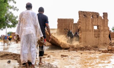 Men bring down the mudbrick wall of a house to act as a make-shift levee amidst flooding in the area of Messawi near Meroe in Sudan's Northern State on August 27.