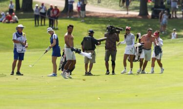 The caddies react to Lee's long-range hole out.