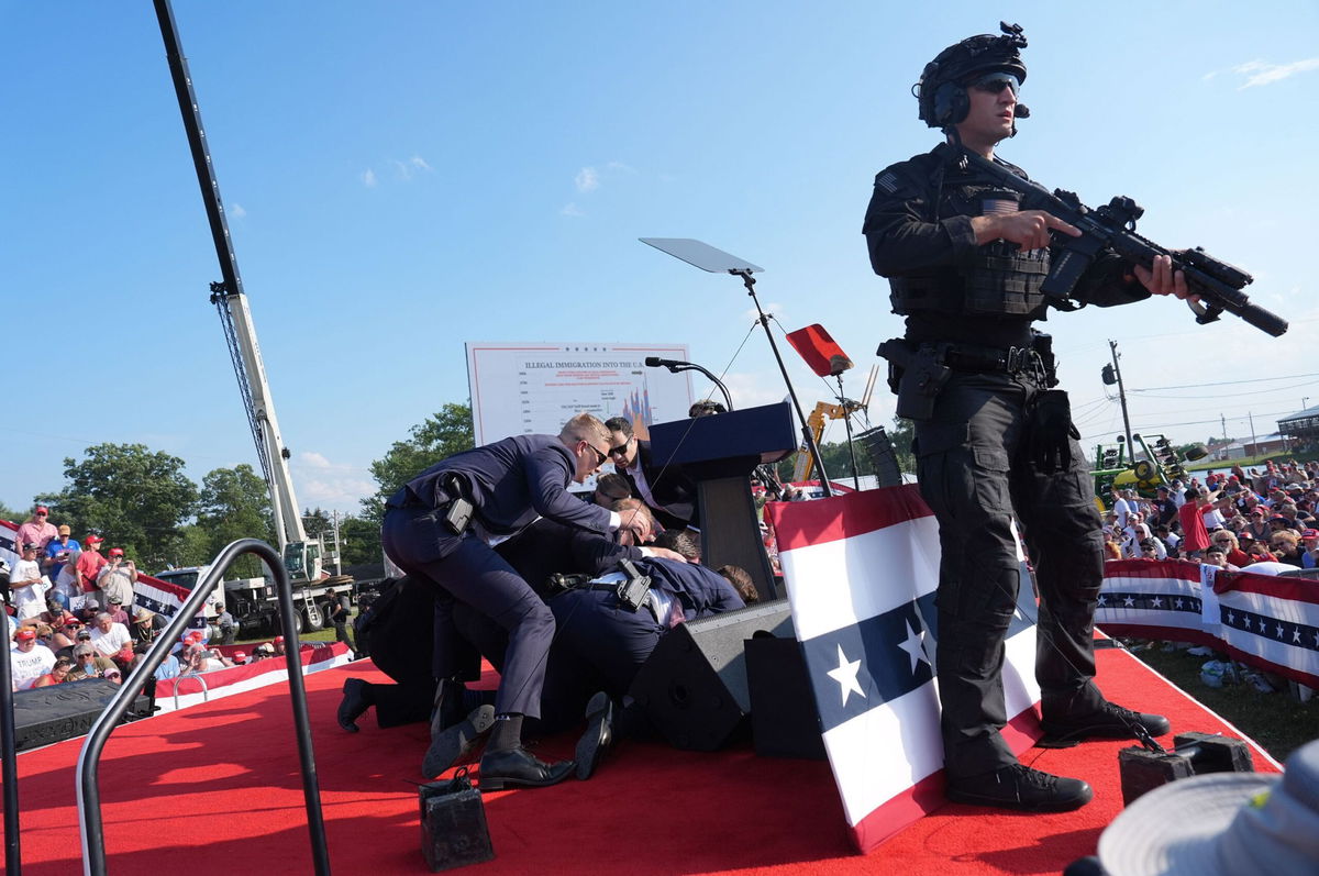 <i>Jabin Botsford/The Washington Post/Getty Images via CNN Newsource</i><br/>Secret Service agents cover former president Donald Trump during a campaign rally for former President Donald Trump at Butler Farm Show Inc. on Saturday