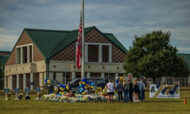 People pay respects at a memorial to the shooting victims at Apalachee High School.