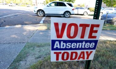 A sign encouraging people to vote absentee stands outside the Hinds County Courthouse in Jackson