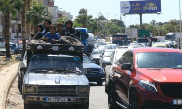 A Syrian family sit with their belongings in the back of a truck as they wait in a traffic jam in the southern Lebanese city of Sidon on September 23.