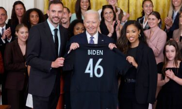 President Joe Biden is presented a jersey from NJ/NY Gotham FC head coach Juan Carlos Amorós and forward Midge Purce during a ceremony.