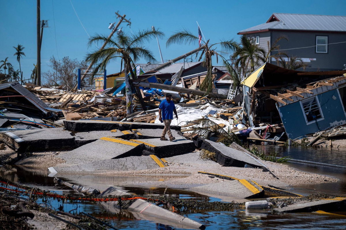 <i>Ricardo Arduengo/AFP/Getty Images via CNN Newsource</i><br/>A man walks over Pine Island Road in Matlacha