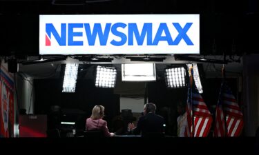 News anchors work at Newsmax's booth during the second day of the 2024 Republican National Convention at the Fiserv Forum in Milwaukee