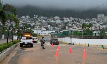 Security forces stands guard on a flooded road after Hurricane John in Acapulco