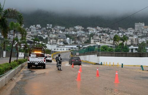 Security forces stands guard on a flooded road after Hurricane John in Acapulco