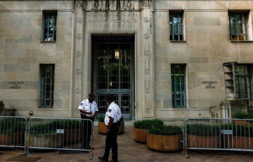 Police officers stand in front of the Department of Justice in Washington