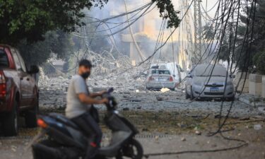 A man rides his motorbike through a neighborhood leveled by Israeli strikes in the Hadath district of Beirut's southern suburbs on September 28.