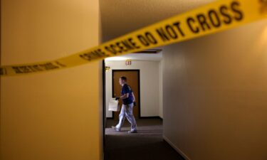 An FBI Evidence Response Team investigator walks behind a crime scene in July 2023 in Fargo