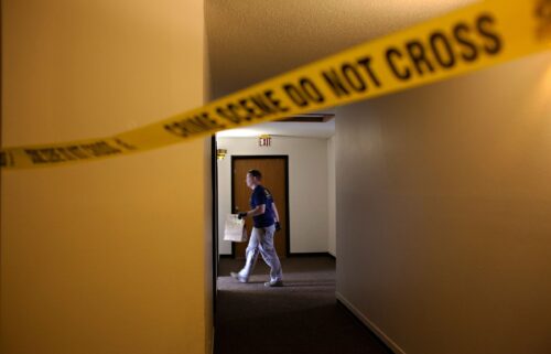 An FBI Evidence Response Team investigator walks behind a crime scene in July 2023 in Fargo