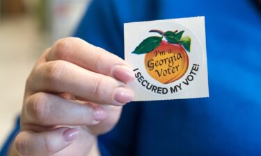 A voter holds up her sticker after casting her ballot for the Primary election on March 12 in Atlanta