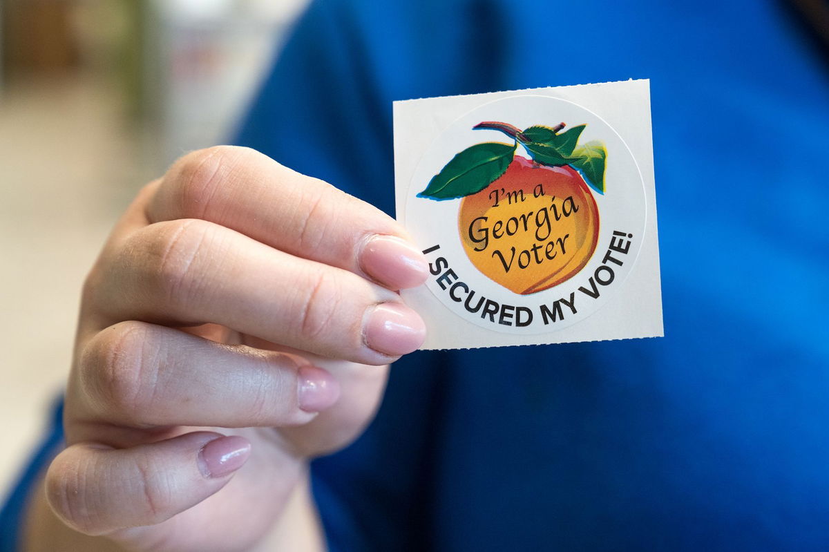 <i>Megan Varner/The Washington Post/Getty Images/File via CNN Newsource</i><br/>A voter holds up her sticker after casting her ballot for the Primary election on March 12 in Atlanta