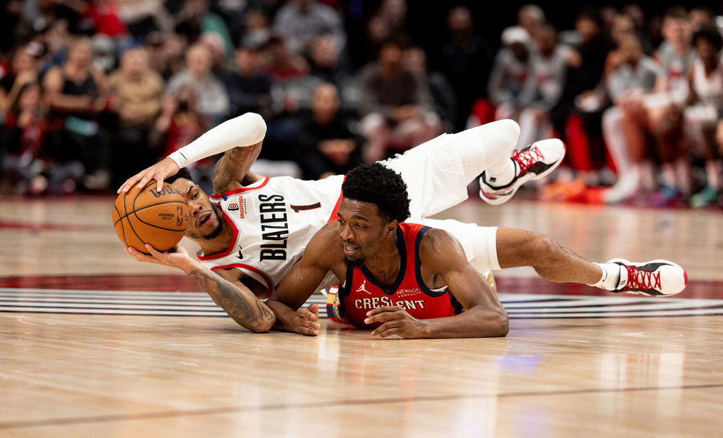 Portland Trail Blazers guard Anfernee Simons, left, dives for the ball against New Orleans Pelicans forward Herbert Jones, right, during the second half of an NBA basketball game Sunday, Oct. 27, 2024, in Portland.