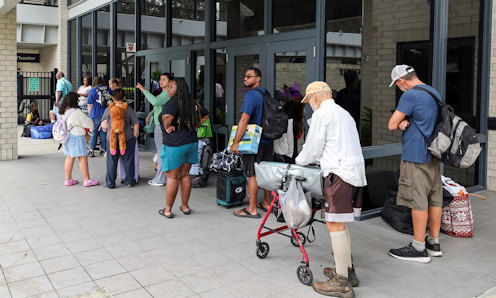 Pasco County evacuees await the opening of the shelter at River Ridge High School in preparation for Hurricane Milton on Monday, Oct. 7, 2024, in New Port Richey, Fla.