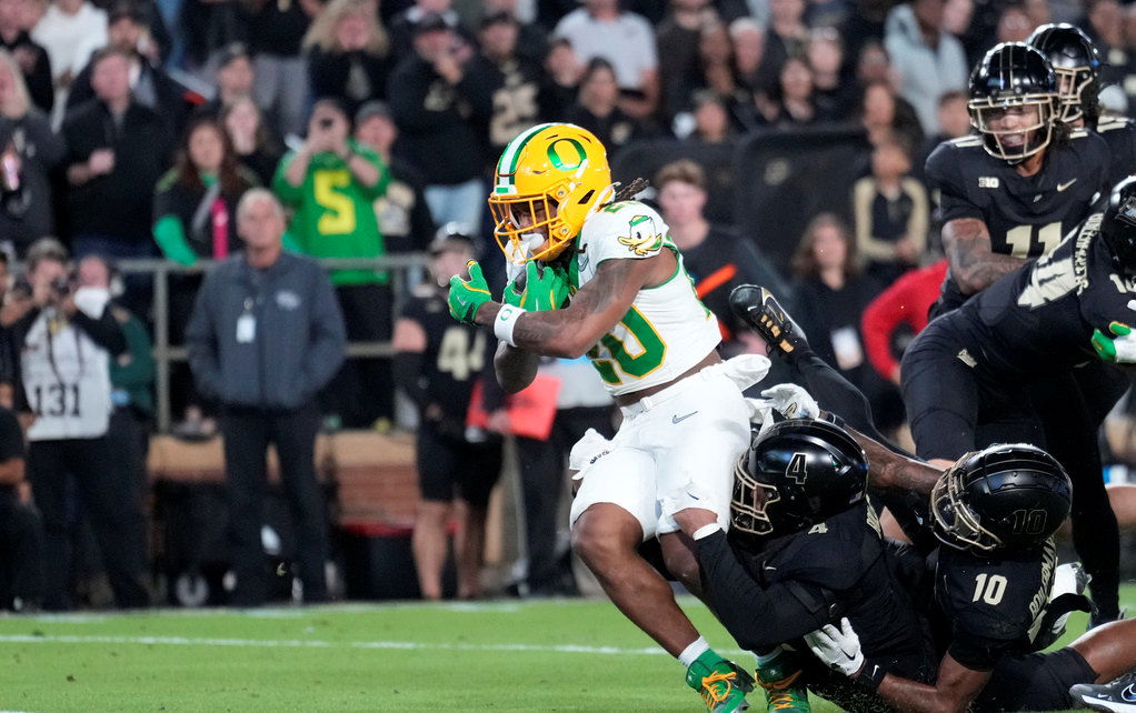 Oregon running back Jordan James (20) scores a touchdown while being tackled by Purdue linebacker Kydran Jenkins (4) in the first half of Friday night's game in West Lafayette, Ind.