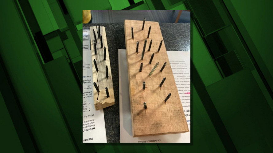 Officials say the boards holding spikes placed across Forest Service roads were covered with leaves to hide them