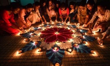 Students in the Indian city of Guwahati light oil lamps on a rangoli