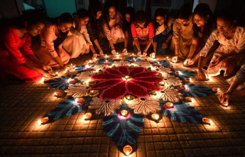 Students in the Indian city of Guwahati light oil lamps on a rangoli