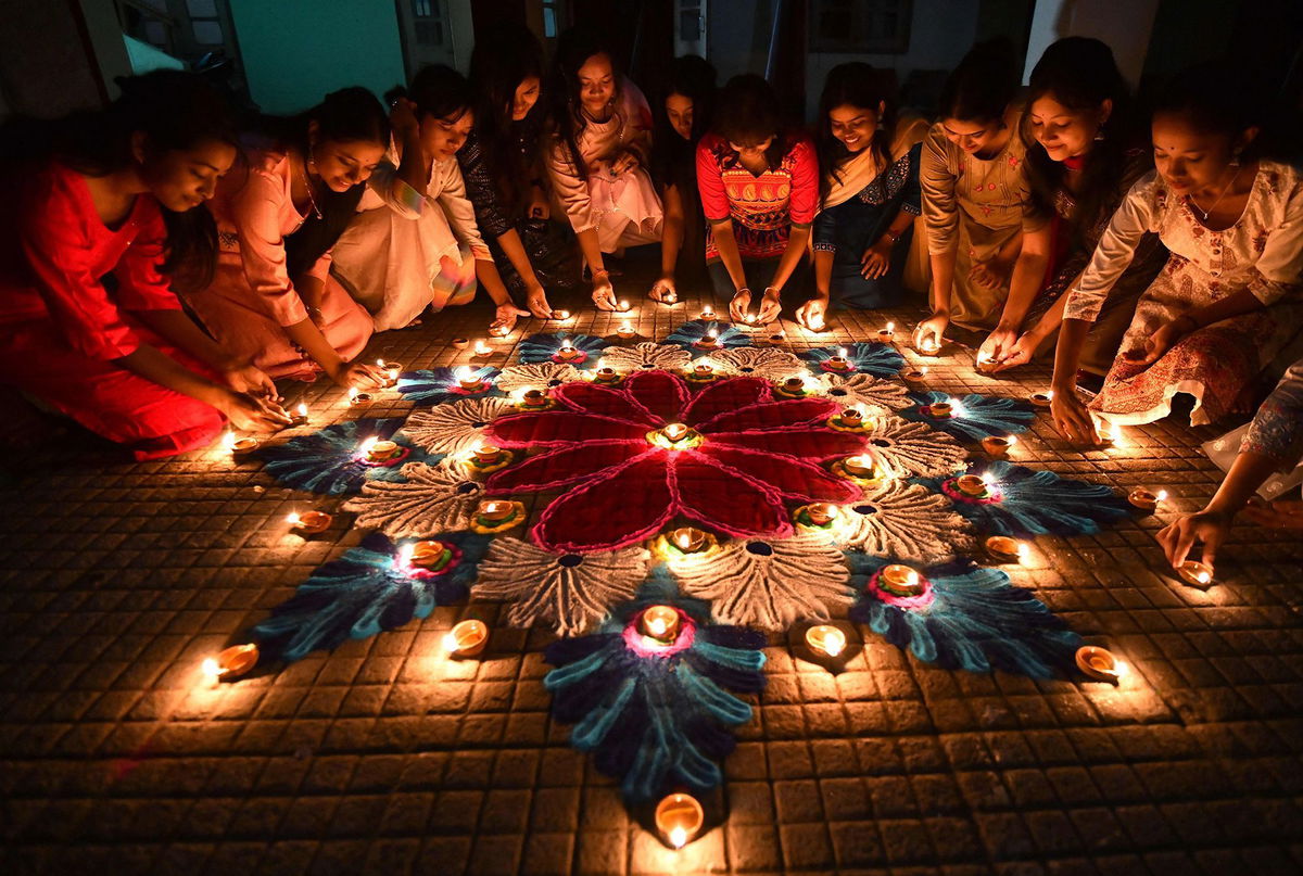 <i>Biju Boro/AFP/Getty Images via CNN Newsource</i><br/>Students in the Indian city of Guwahati light oil lamps on a rangoli