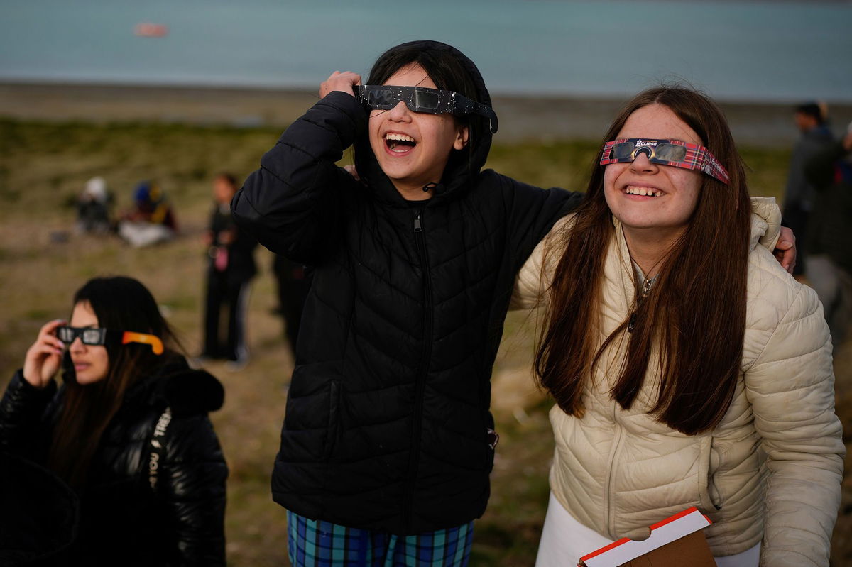 <i>Natacha Pisarenko/AP via CNN Newsource</i><br/>People watch as an annular solar eclipse appears Wednesday in the sky over Puerto San Julián