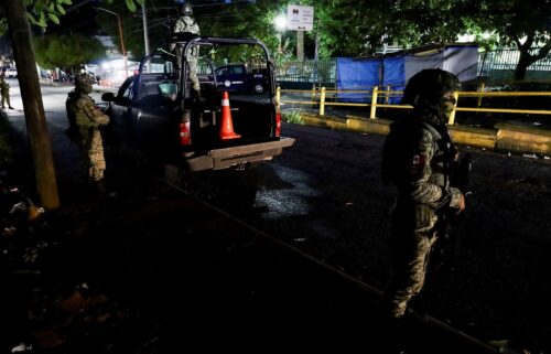 Soldiers stand guard outside a hospital where injured migrants were taken after Mexican soldiers shot a group of 33 migrants in Tapachula