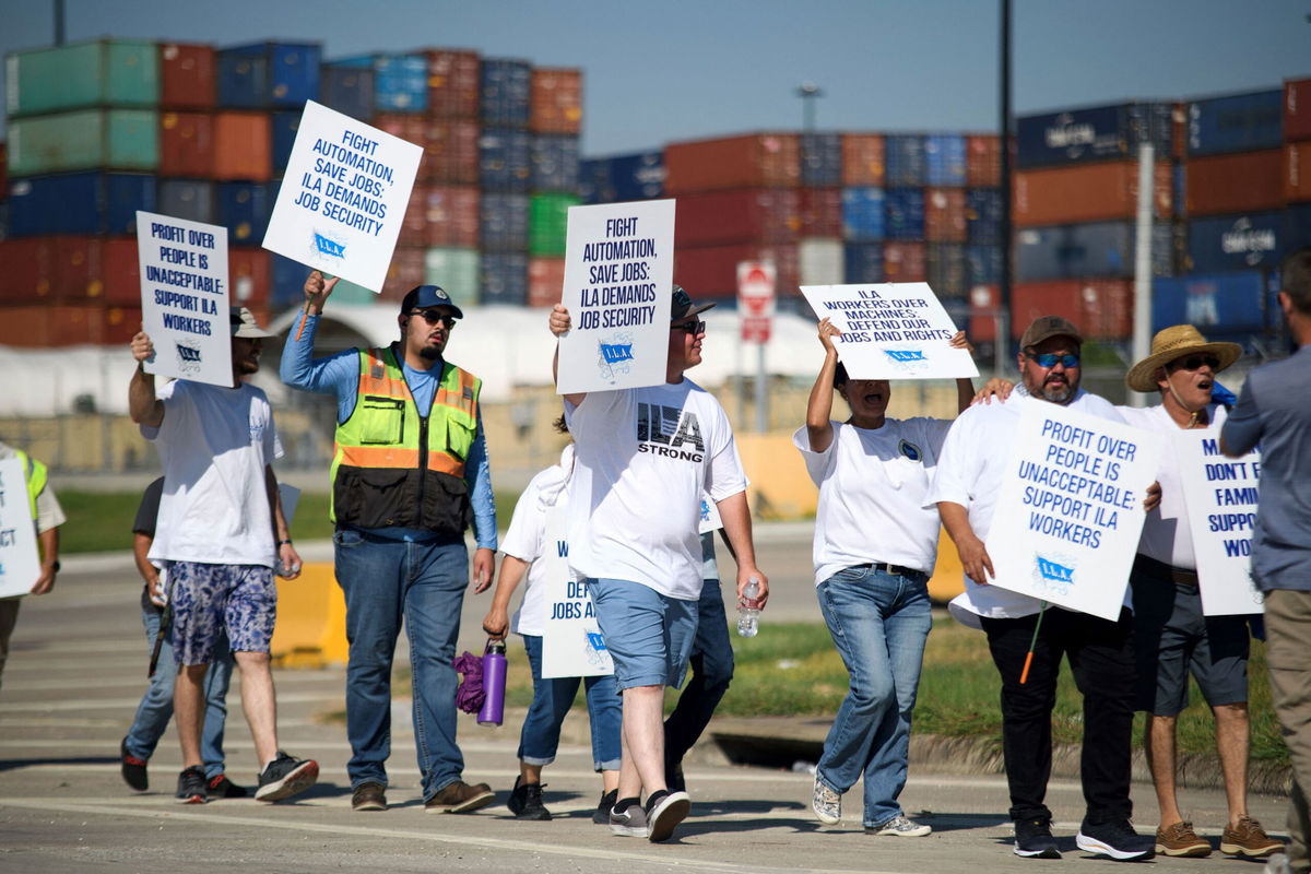 <i>Mark Felix/AFP/Getty Images via CNN Newsource</i><br/>Striking workers hold up signs and march in front of the Bayport Container Terminal in Seabrook