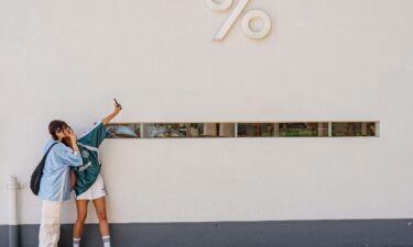 Girls take pictures in front of a Kennedy Town district cafe in Hong Kong.