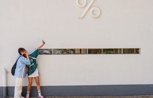 Girls take pictures in front of a Kennedy Town district cafe in Hong Kong.