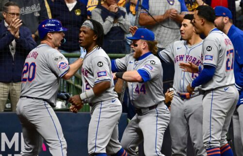 Mets players celebrate with Alonso (left) after his home run.