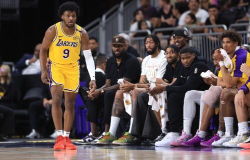 LeBron James watches the game from the bench as Bronny James makes his preseason debut.