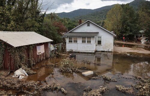 An American flag hangs above floodwaters remaining from Hurricane Helene on Friday