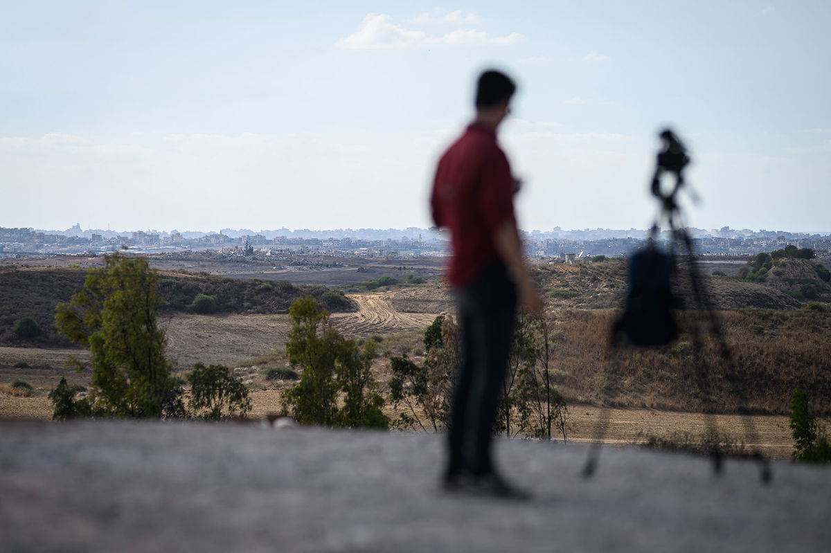 <i>Leon Neal/Getty Images via CNN Newsource</i><br/>A journalist looks towards Gaza from a viewpoint in Southern Israel on October 7 in Sderot