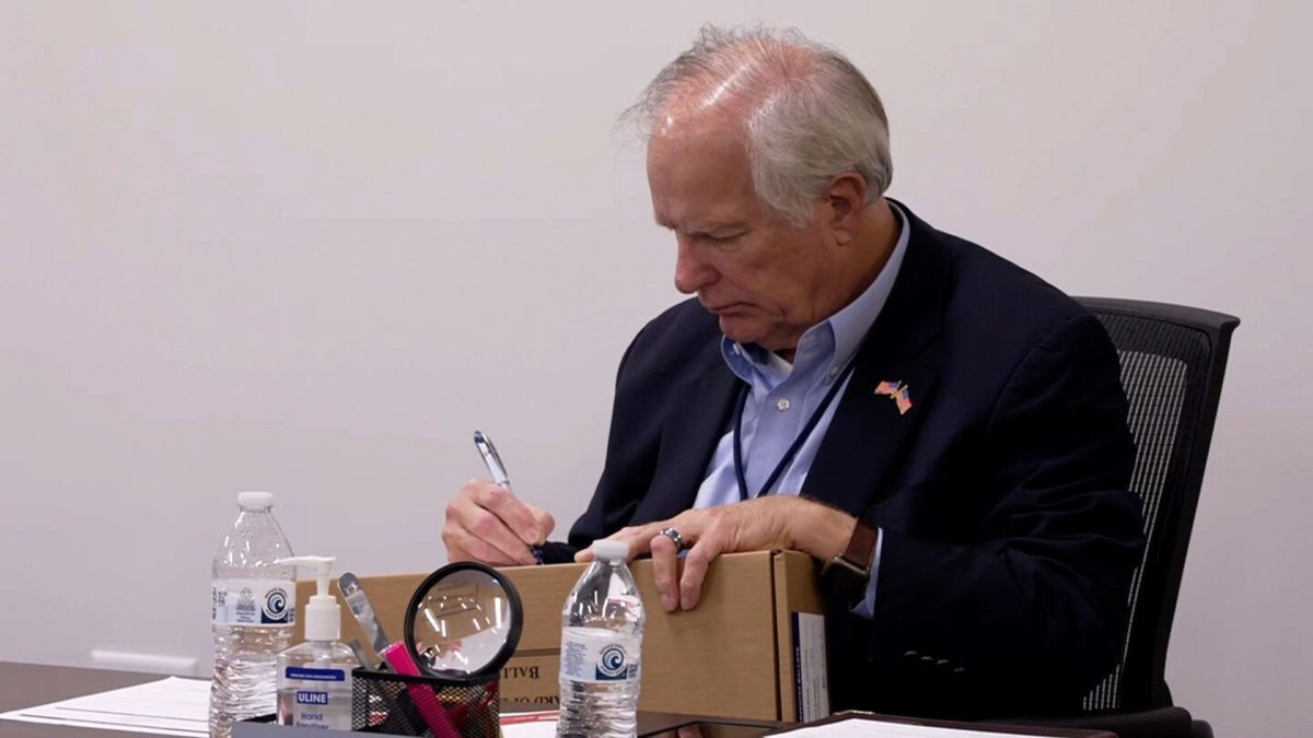 <i>CNN via CNN Newsource</i><br/>Wake County Board of Elections member Keith Weatherly signs a box of mail-in ballots at the Wake County Board of Elections ballot processing center in Raleigh