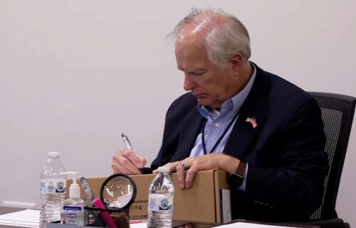 Wake County Board of Elections member Keith Weatherly signs a box of mail-in ballots at the Wake County Board of Elections ballot processing center in Raleigh